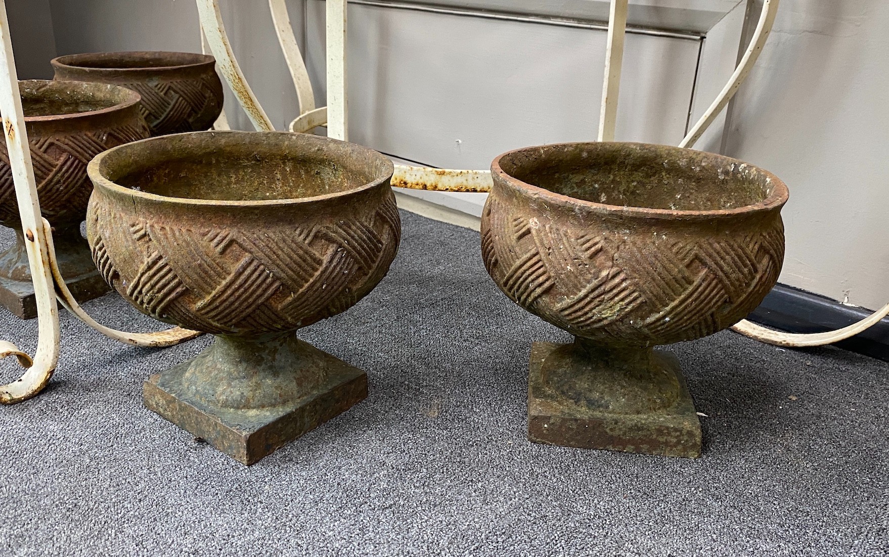 A set of four cast iron urns, diameter 24cm, height 23cm